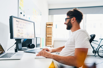 Young photographer working in home office editing and choosing pictures