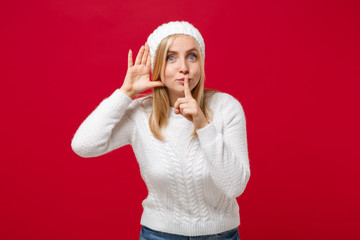 Young woman in white sweater, hat isolated on red background. Healthy fashion lifestyle cold season...