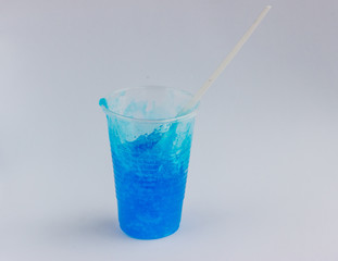 Plastic cup with a toy called blue slime and a plastic white spoon on a light background. Funny toy for children's leisure and creativity. Selective focus. Copy space for text..