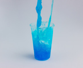 Plastic cup with a toy called blue slime on a light background. Funny toy for children's leisure and creativity. Selective focus. Copy space for text..