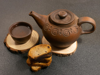 clay teapot with a cup and breadcrumbs