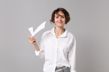 Smiling attractive young business woman in white shirt posing isolated on grey wall background...