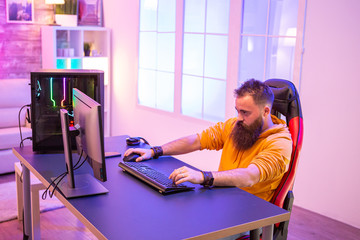 Professional gamer with long beard in front of powerful gaming rig © DC Studio