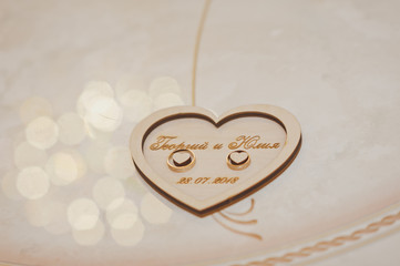 Wedding rings on a wooden stand with names 2474.