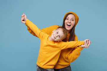 Woman in yellow clothes have fun posing with cute child baby boy 4-5 years old. Mommy little kid son isolated on blue background studio portrait. Mother's Day love family parenthood childhood concept.