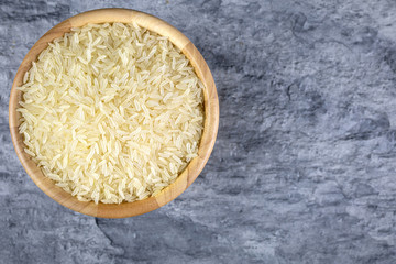 Parboiled rice in a wooden cup laid on stone sheets