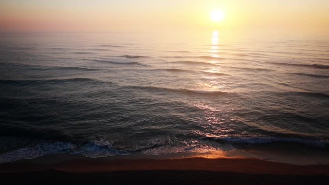 HD footage of the sunrise at the sea, with birds flying by.