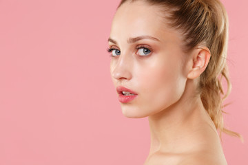 Close up blonde half naked woman 20s perfect skin nude make up blue eyes isolated on pastel pink...