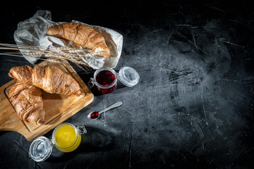 Freshly baked croissants on dark background. Perfect breacfast in the morning
