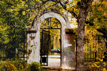  old white arch with a rickety wicket on a background of autumn