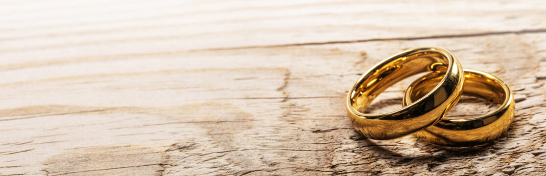 Golden wedding rings on wood