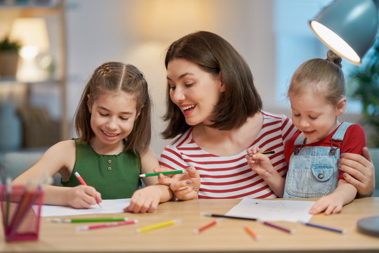 Mother and daughters drawing together