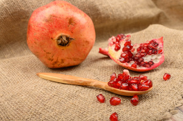 Grains of ripe juicy pomegranate, pomegranate and pieces of pomegranate on a wooden background....