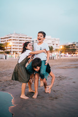 Fototapeta na wymiar Children havig fun on the beach at sunset