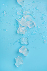 ice cubes with water drops on blue background. abstract ice background. Flat lay, top view. copy...