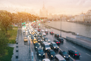 Daytime traffic of cars in Moscow. Light from headlights of cars and buildings. The movement of cars in the city center. Blurred background and rainy weather