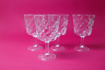 Obraz premium Four wine glasses on pink background with copy space.
