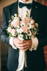 wedding bouquet in hands of  groom