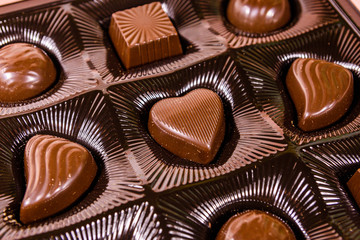 Heap of chocolate candies in a brown box