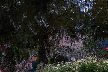 Abstract background of bright blurry multi-colored spots with the effect of flowing water.