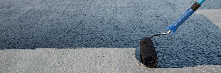 Worker applies bitumen mastic on the foundation