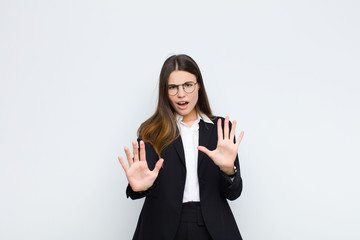 young businesswoman feeling terrified, backing off and screaming in horror and panic, reacting to a...