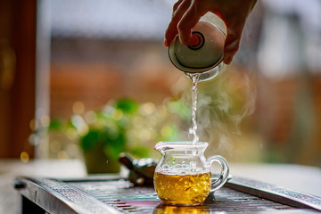 Tea brewing process, tea ceremony, a cup of freshly brewed green oolong tea, warm soft light. Soft...