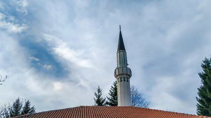 Obraz premium View of mosque minaret and roof in old oriental eastern design style with islamic architecture for prayer and a cultural significance