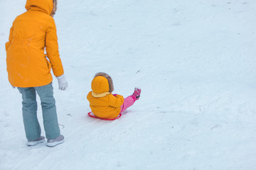 mother with daughter sliding from winter hill