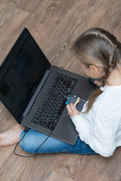 Minsk, Belarus. January, 2020. The BBC robot Micro Bit is connected to a computer. A cute little girl is programming it on Scratch and Python. Creative. Connected. Coding. Learning, teaching easy.