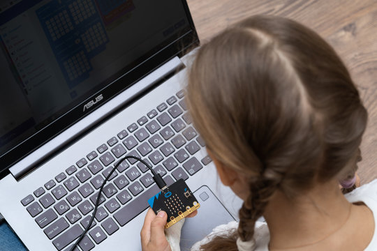 Minsk, Belarus. January, 2020. The BBC robot Micro Bit is connected to a computer. A cute little girl is programming it on Scratch and Python. Creative. Connected. Coding. Learning, teaching easy.