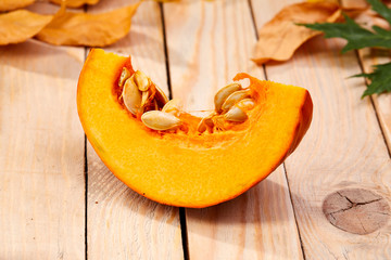 fresh pumpkin and leaves on the wooden background