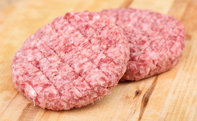 Soft focus. Raw pink beef cutlet isolated on a cutting board.