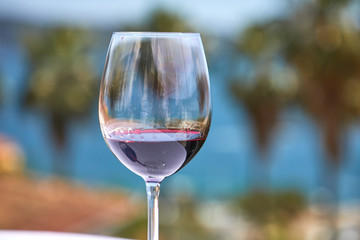 glass of red wine near sea