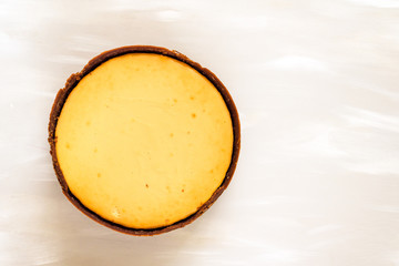 whole, freshly baked cheesecake on a neutral background