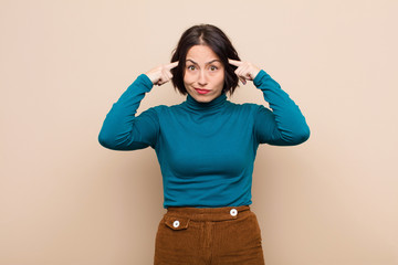 young pretty woman with a serious and concentrated look, brainstorming and thinking about a...
