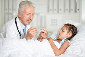 Fototapeta premium Portrait of man doctor and girl in hospital