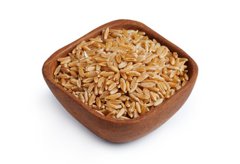 Khorasan wheat or kamut (Triticum turgidum) in wooden bowl isolated on white background