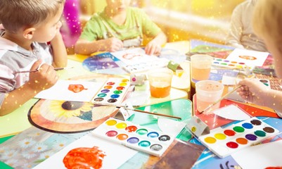 Little children with colorful painted hands on class background