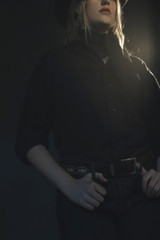 Fototapeta na wymiar Blonde cowgirl in black shirt and hat.
