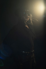 Blonde cowgirl in black hat wearing dark sunglasses.