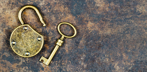 Solution, success concept, gold key and unlocked padlock on metal background
