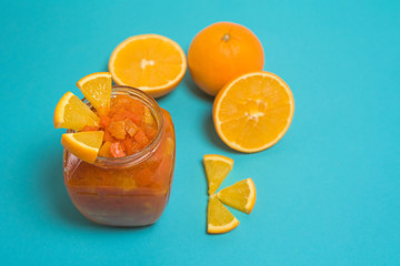fresh nutritious orange jam with pumpkin slices, healthy Breakfast with proper nutrition. jam in a glass jar on a blue background