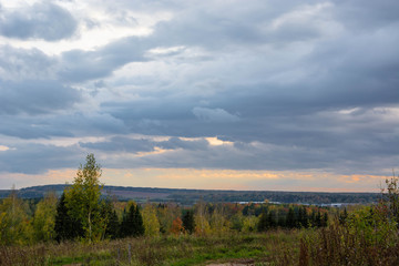 Autumn landscape. Russian nature. Cloudy weather. Meadow and trees.