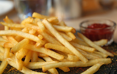 Tasty French fries with red sauce served on table in cafe, closeup