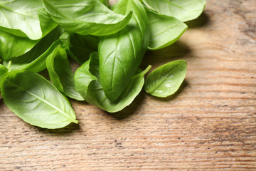 Fresh basil leaves on wooden table, closeup