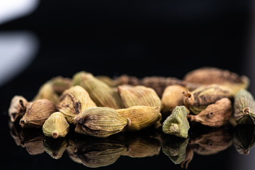 whole cardamom and broken next to test tube and cork