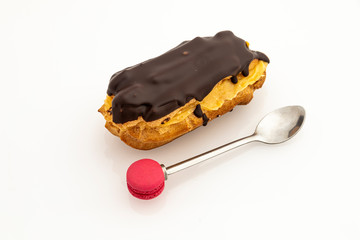 Chocolate covered cake filled with cream and with a spoon