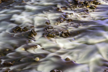 Long exposure of water in a mountain stream at night makes it white and silky smooth, in contrast with the dark small rocks