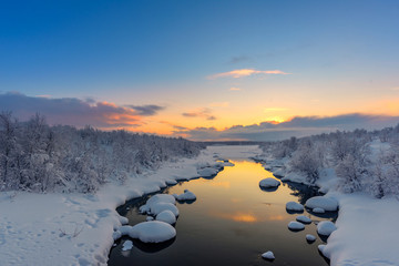 Winter sunset over the Teriberka river above the Arctic Circle in the Kola Peninsula, near...